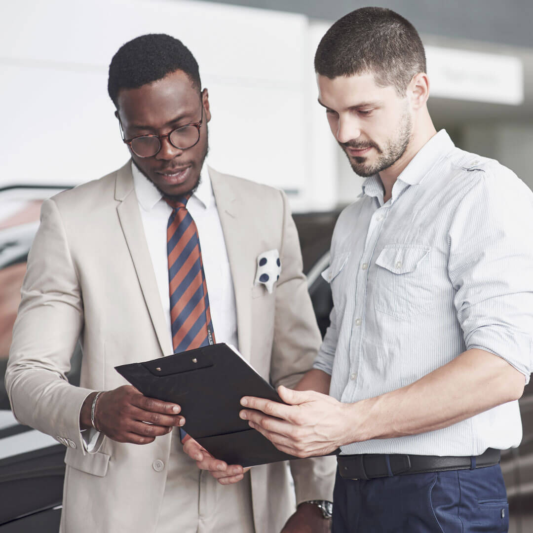Car salesman explains electric vehicles to customer