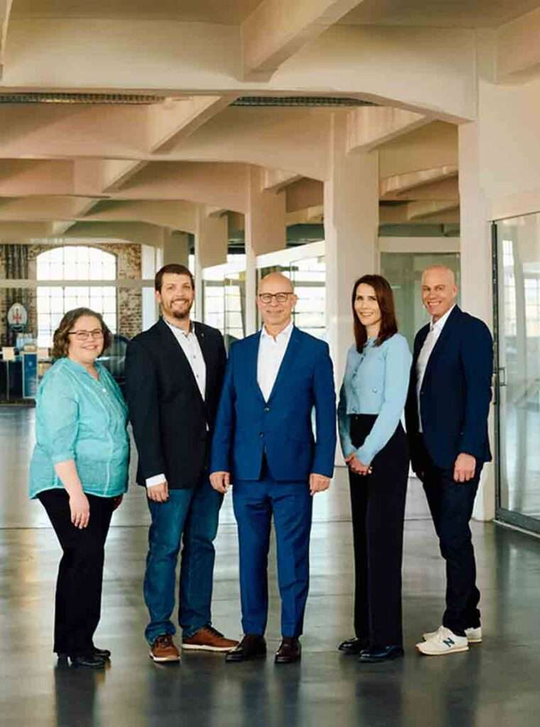 Gruppe von fünf Personen in Anzügen.