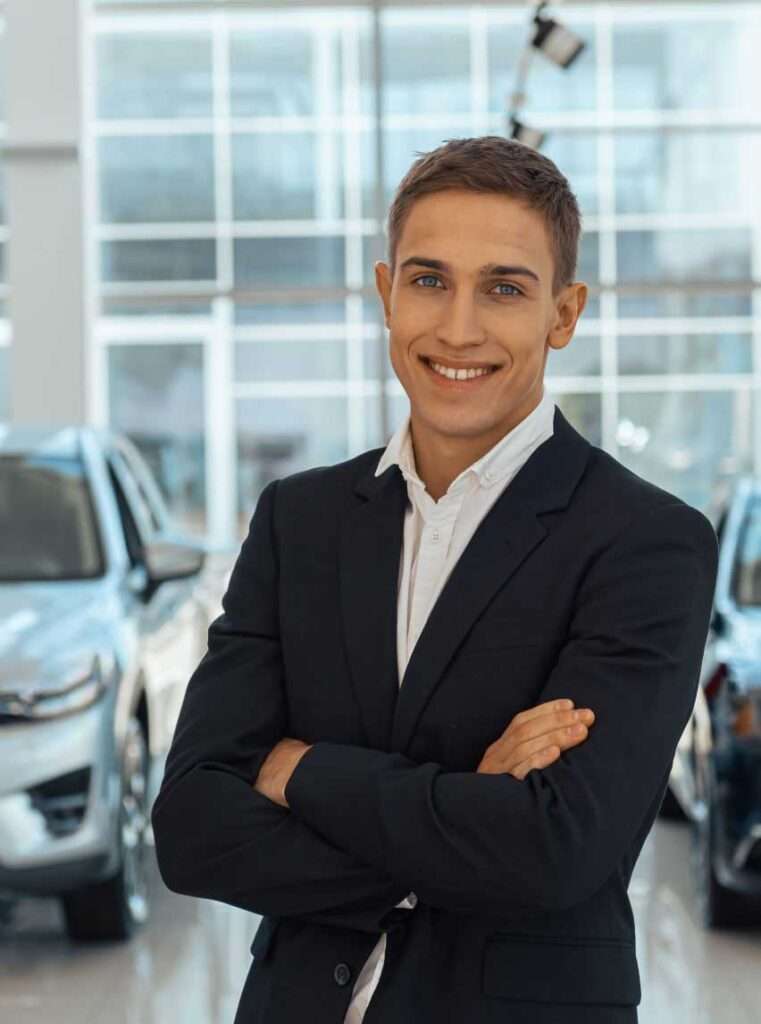 Lächelnder Mann im Anzug im Autohaus