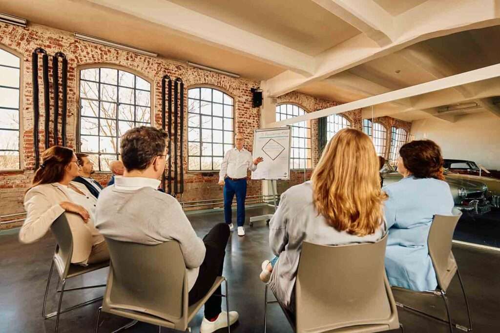 Schulungsteilnehmer sitzen in einem Stuhlkreis